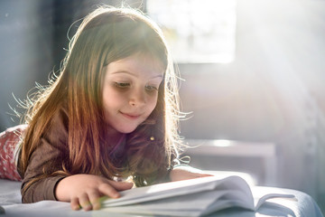 Cute Girl Reading a Book at Home