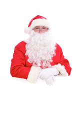 Kind Santa Claus looking out from behind the blank sign isolated on white background with copy space