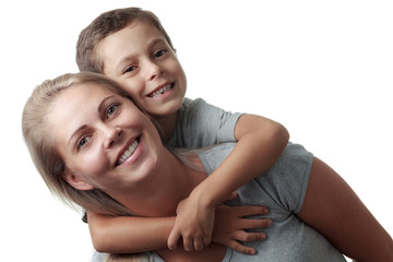 Fototapeta premium Son hugging his mother from behind and she smiling isolated on w