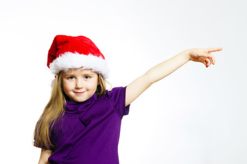 Cute little girl in santa red hat showing by hand