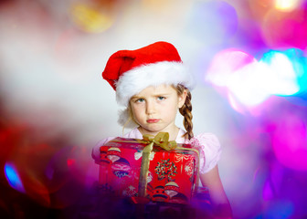 Fototapeta na wymiar Pretty little girl dressed in santa red hat, new year portrait w