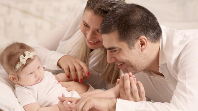 Cheerful parents playing with their cute adorable little baby daughter, cheerful young family. Full HD Video 1920x1080