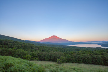 Obraz premium Red color at Top of Mountain Fuji in summer early morning seen from Lake Yamanaka , Yamanashi prefecture