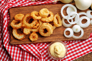 Chips rings with sauce and onion on cutting board