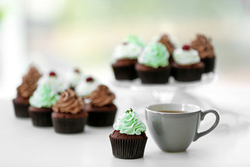 Beautiful chocolate cupcakes and cup of tea,  on table