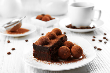 Slice of chocolate cake with a truffle on plate closeup