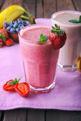 Glasses of fresh cold smoothie with fruit and berries, on the table, close-up