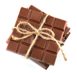 Milk chocolate bar with bow on color wooden background
