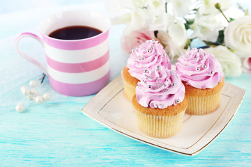 Tasty cupcakes on plate, on light background