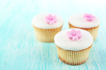 Tasty cupcakes on color wooden background