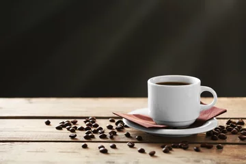 Deurstickers Cup of coffee and coffee grains on wooden table, on gray background © Africa Studio