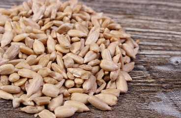 Heap of sunflower seeds on wooden background