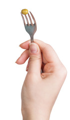 green pea seed impaled on fork in female hand