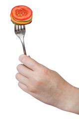 fresh sliced vegetables impaled on fork in hand