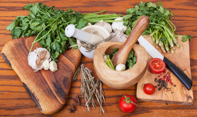 mortars and fresh herbs on wooden table