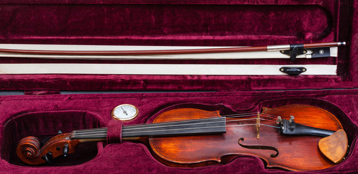 old fiddle with bow in red velvet case
