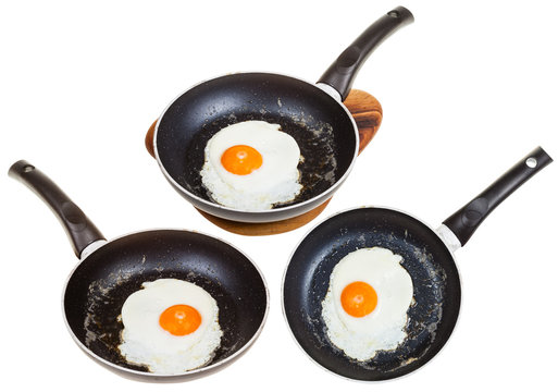 set of frypans with one fried egg isolated