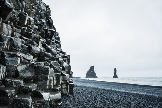 Mount Reynisfjall with basalt columns and Reynisdrangar rock for