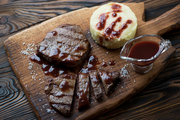 Grilled marbled beefsteaks served with mashed potatoes and sauce