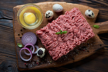 Top view of raw ground beef meat with seasonings, studio shot