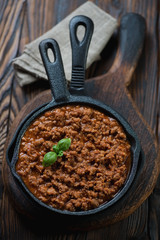 Cast-iron frying pan with bolognese sauce, high angle view