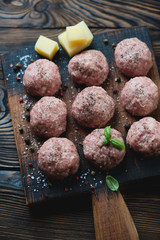 Uncooked meatballs with seasonings, close-up, selective focus