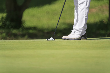 Fototapeta na wymiar Golfer putting, selective focus on golf ball