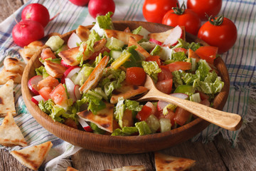 Vegetable salad with pita close up in a wooden bowl
