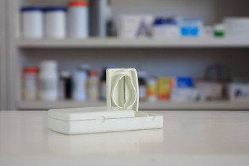 tablet cutter with blur shelves of drug in the pharmacy drugstor