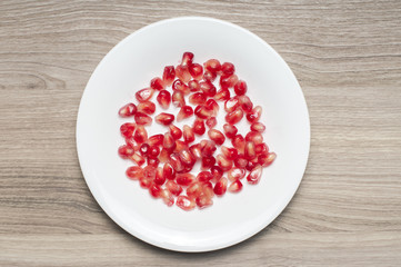 Seeds of the garnet on the white plate.