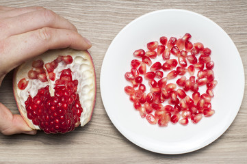 Take it. Man take  part of the garnet from the table. The seeds