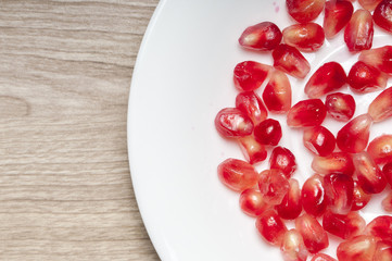 Seeds of the garnet on the white plate.