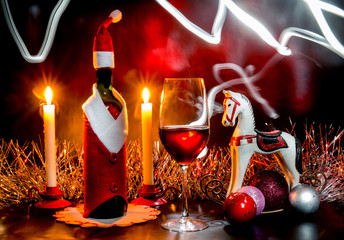 Christmas still life with a wine bottle, candles and a wine glas