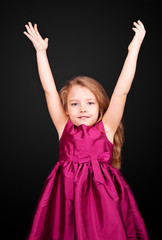 Little cute girl in a pink dress fun hands up