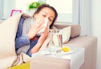 Fototapeta na wymiar Flu. Sick woman sneezing into tissue