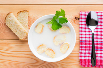 creamy soup with croutons in a bowl on a table