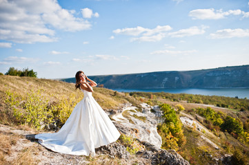 Fototapeta na wymiar Very sensual and gorgeus bride on the picturesque landscapes