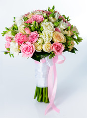 Close-up of bridal bouquet in pink colors on a gray background.