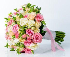 Close-up of bridal bouquet in pink colors on a gray background.