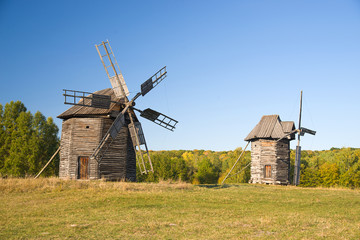 Fototapeta na wymiar Windmills standing on the edge of the autumn forest