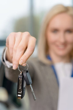 Saleswomans hand grasping the car keys.