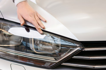 Hand checking the car surface. 