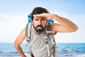 backpacker showing something over white background