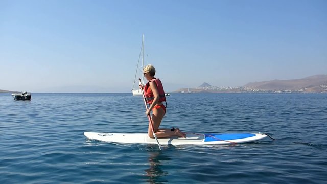 Une femme pratiquant le stand up paddle