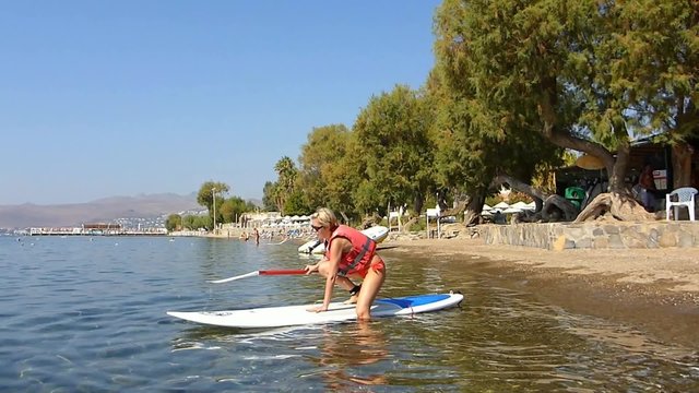 Une femme pratiquant le stand up paddle