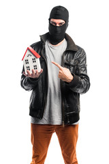 Robber holding a little house