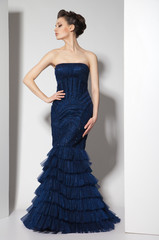 young beautiful brunette in dark blue dress on white