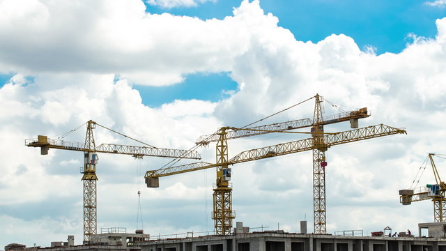 4K video time lapse : Construction site with cranes and blue sky background with downward movement.