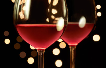 two glasses of red wine. background with the illumination lighting. Romantic and luxury. 