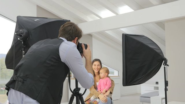 Photographer taking picture of woman with baby